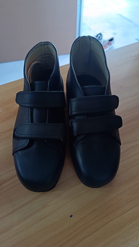 Sepasang kasut hitam custom dengan bukaan velcro