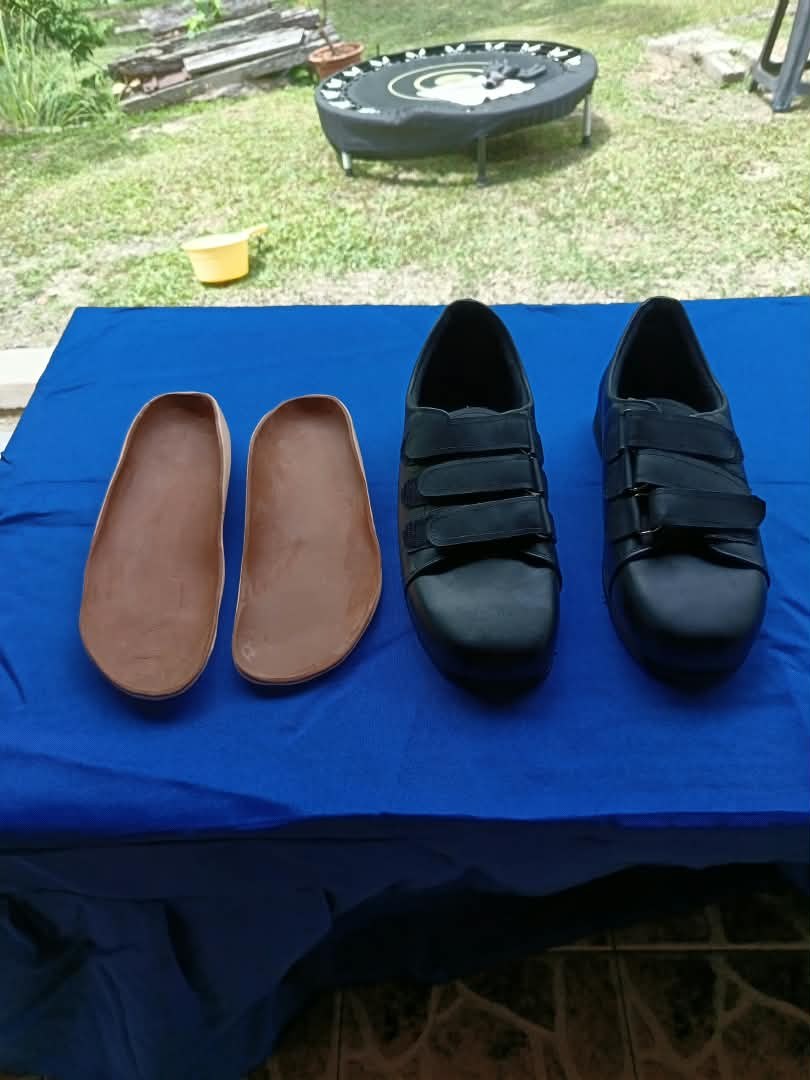 Set kasut hitam dan custom insole pada meja
